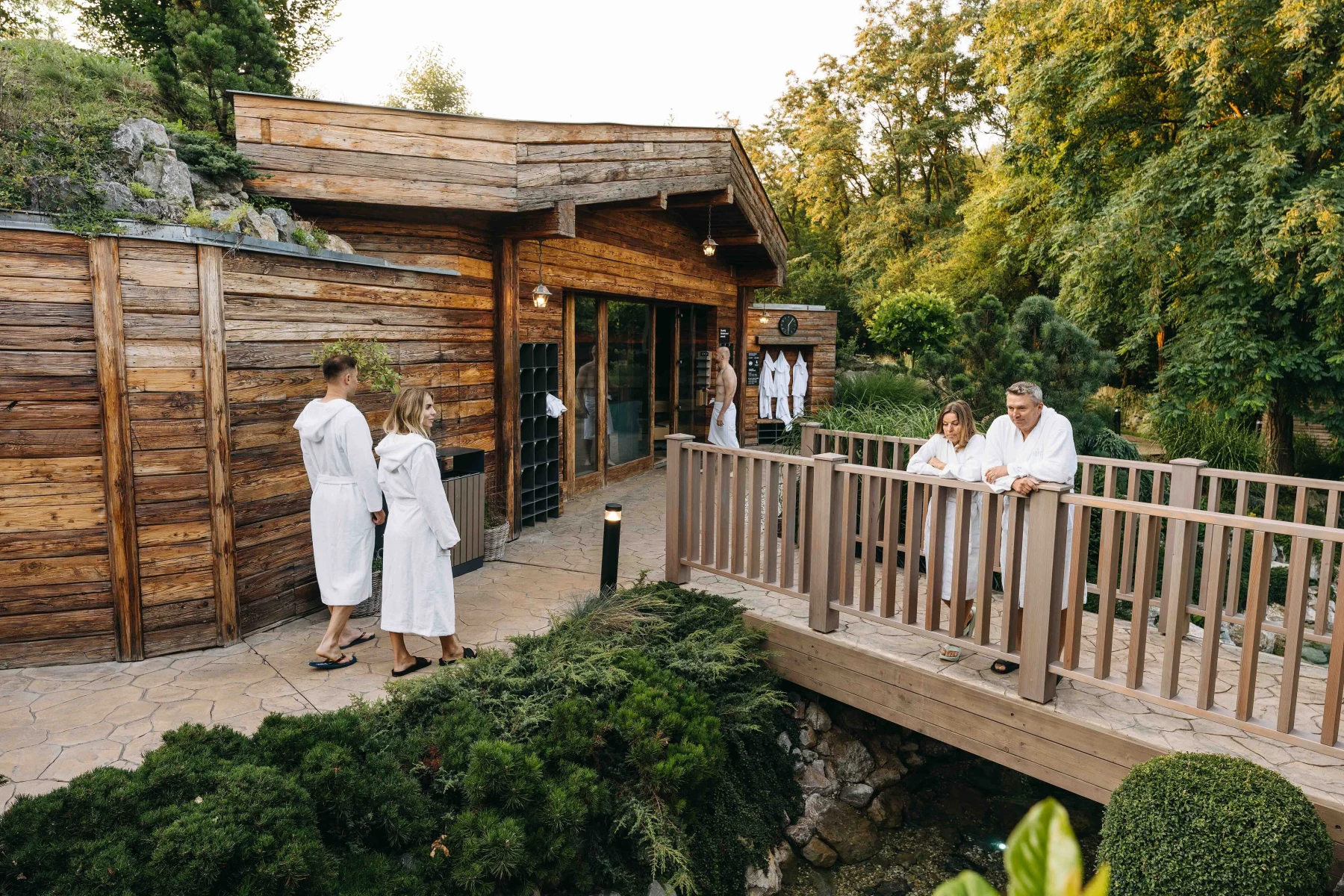2025_08_MAX_venkovni wellness s lidmi pohled jeskyni a mostek